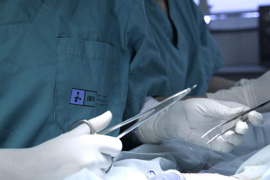 Fotografía de las manos de un médico del IBV realizando una sutura en quirófano
