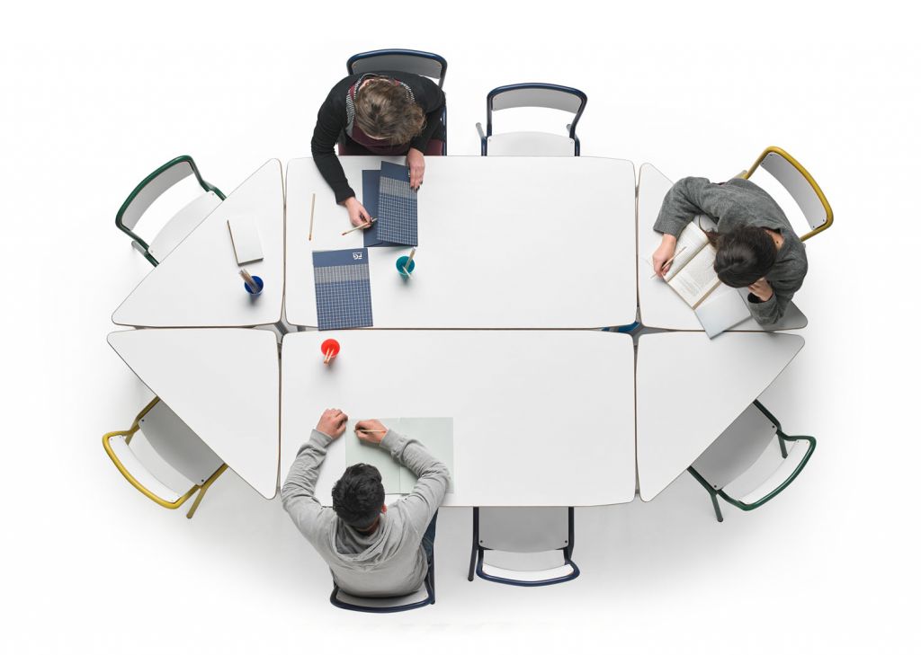Fotografía cenital de dos personas trabajando en unas mesas modulares