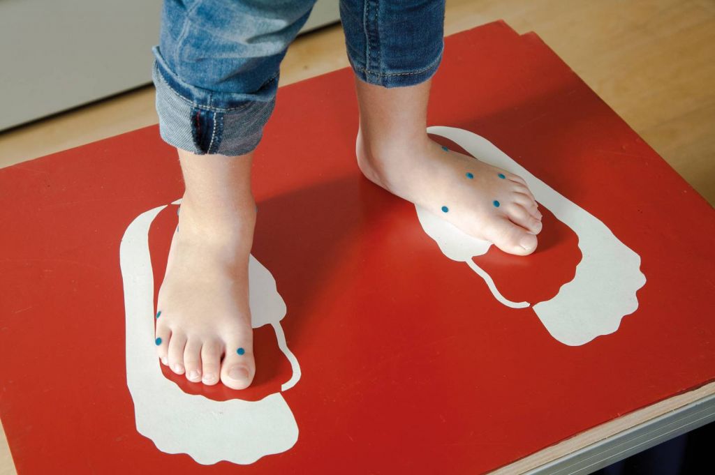 Fotografía de unos pies de niño en máquina para medirlos