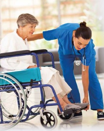 Fotografía de mujer sanitaria ayudando a una mujer mayo en silla de ruedas