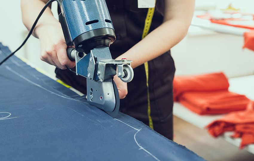 Fotografía de una operaria con una máquina de corte en una empresa textil para el proyecto Ergonómicos textil