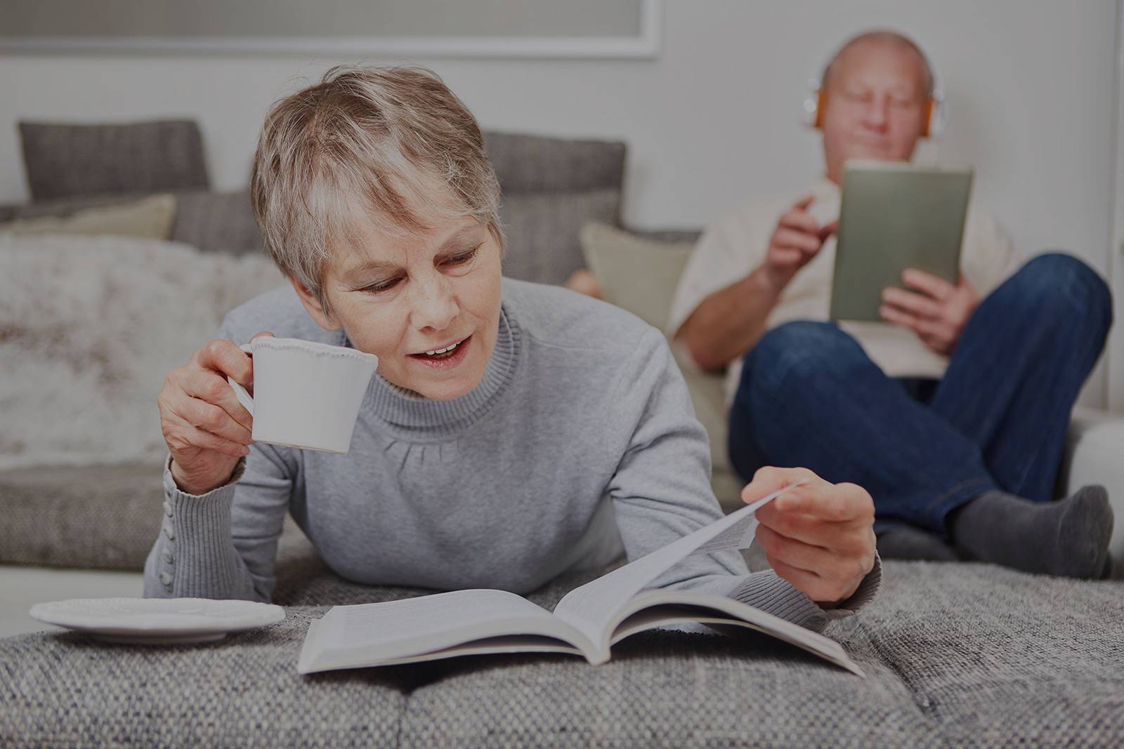 An elder couple reading and relaxing in a couch